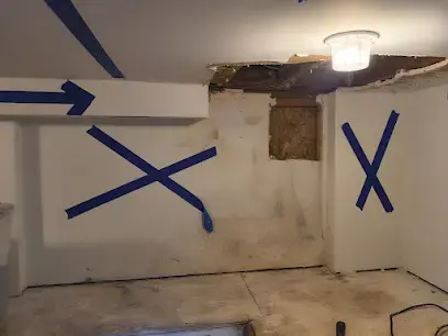 Wall marked with tape where moisture readings ran high, below an opened ceiling, Granada Hills water damage