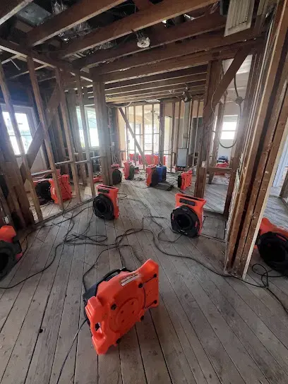 Air movers spread across the subfloor of a home opened down to the framing, Granada Hills structural drying
